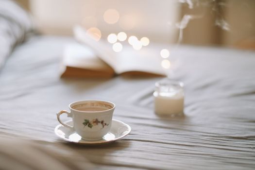 Spring still life. Breakfast in bed. White bedroom. Sweet home. Book and coffee cup