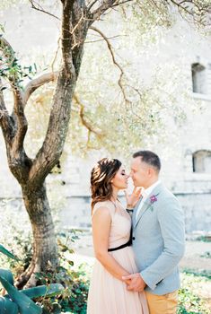 Bride and groom almost kiss near the old fortress. High quality photo
