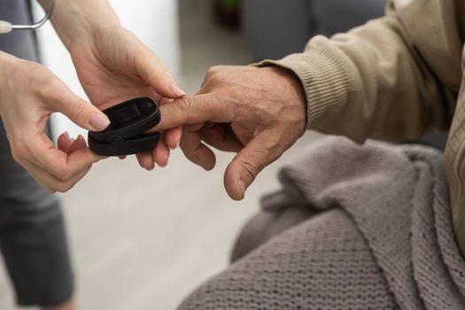 Nurse use pulse oximeter to check patient's oxygen in home, Home healthcare service concept