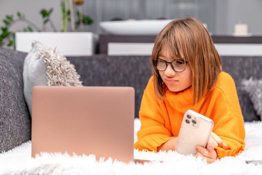 disappointed kid looking at laptop at home on sofa. High quality photo