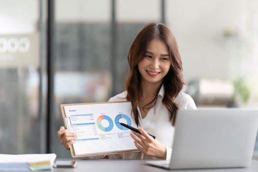 Businesswoman while working with laptop at office desk, platform responsive design for project analysis, analyzing statistics data, analyzing graph.