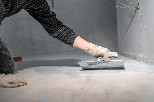 work with trowel on floor and wall in new room in building. High quality photo