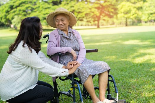 Caregiver help and care Asian elderly woman use walker with strong health while walking at park in happy fresh holiday.