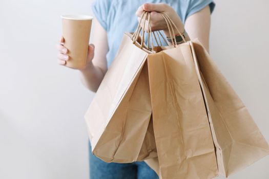 Delivery concept background. Woman hands holding craft paper bags on white, copy space, banner, close-up.