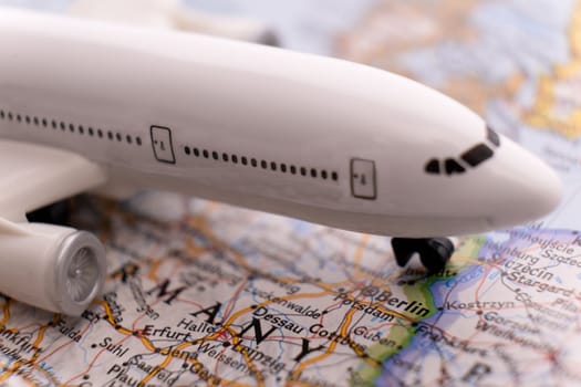 Close up of map with miniature passenger plane highlighting Berlin, Germany through selective focus, shallow depth of field, background blur. High quality photo