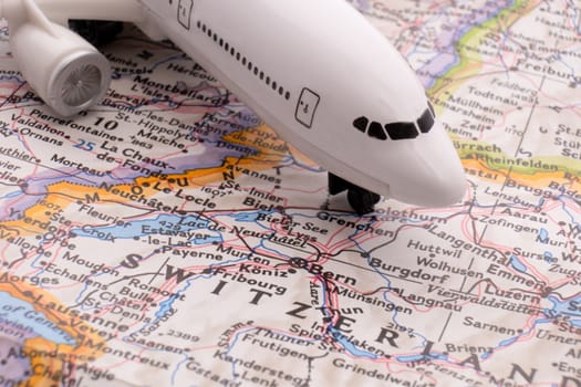 Close up of map with miniature passenger plane highlighting Bern, Switzerland through selective focus, shallow depth of field, background blur. High quality photo