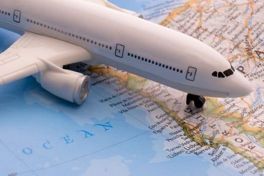 Close up of map with miniature passenger plane highlighting Lisbon, Portugal through selective focus, shallow depth of field, background blur. High quality photo