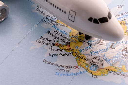 Passenger plane on a map highlighting Reykjavik, Iceland through selective focus, background blur. High quality photo