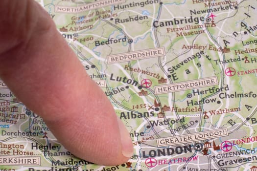 Close up of detailed map with finger pointing to London, England with selective focus, shallow depth of field, background blur. High quality photo