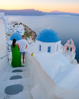 Couple on vacation in Santorini Greece, men and women visit the whitewashed Greek village of Oia during summer vacation on a sunny day