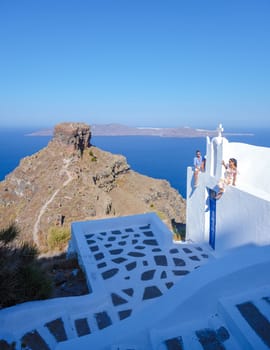 A couple visit Fira capital of Santorini island and the view of a volcanic caldera, Santorini, Greece.men and women with a white church in Greece