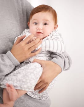 Mommy says only one more month before I start crawling. Portrait of a baby in her mothers arms