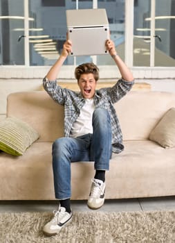 Technology can be infuriating. A young man looking frustrated while holding up his laptop