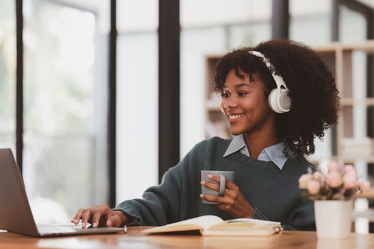 Young black African woman wear headphone and enjoy with music via music app on mobile phone