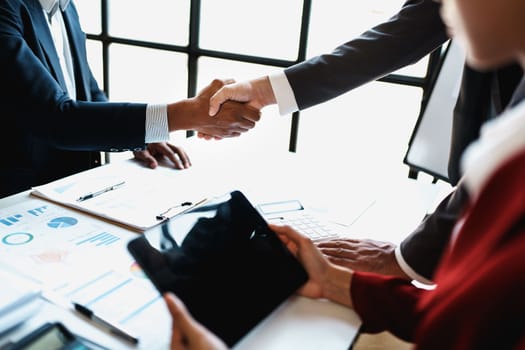 Asian entrepreneurs handshakes to congratulate the agreement between the two companies to enhance investment and financial strength. deal concept.