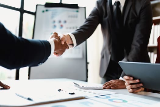 Asian entrepreneurs handshakes to congratulate the agreement between the two companies to enhance investment and financial strength. deal concept.