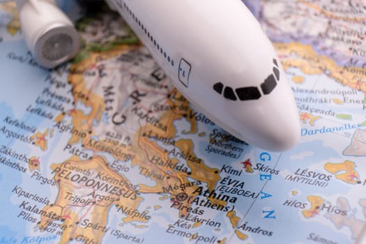 Close up of a miniature passenger plane on a colorful map highlighting Athens, Greece through selective focus, background blur. High quality photo