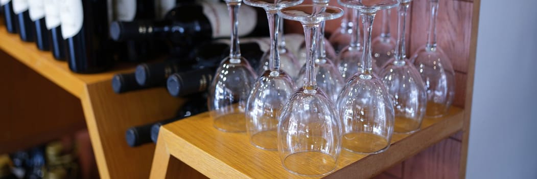 Bottles of wine wine glasses on cabinet rack. Selection of quality wine concept