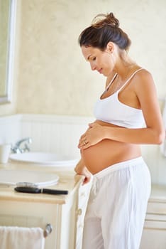 The pregnancy glow. a pregnant woman holding her belly