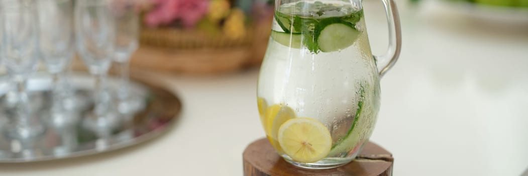 Fruit water with lemon lime cucumber and mint in glass jug. Summer cold drink concept