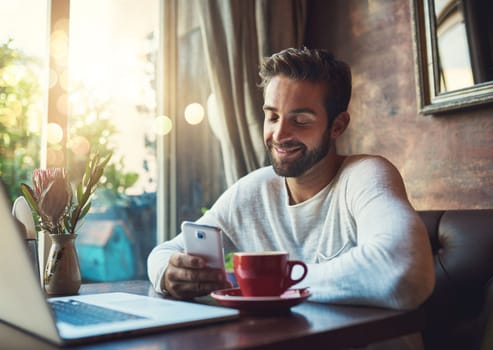 Some messages just make you smile. a young man using his cellphone in a coffee shop