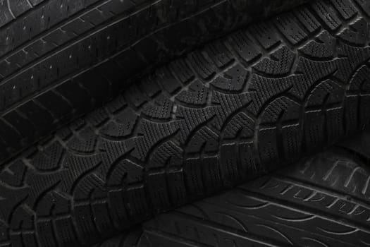 Old used black car or truck wheel tires background
