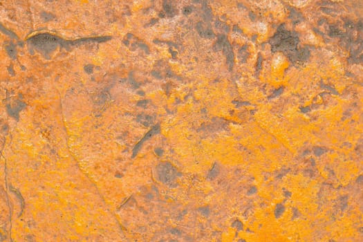Grunge yellow orange old painted concrete or stone wall background texture with stains of faded paint peel and scaling, uneven and weathered