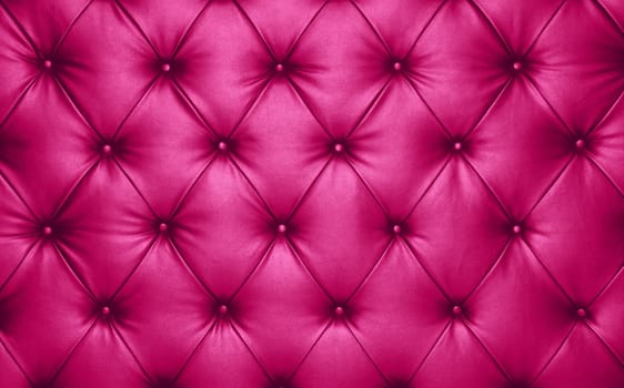 Close up background texture of vivid purple pink capitone genuine leather, retro Chesterfield style soft tufted furniture upholstery with deep diamond pattern and buttons