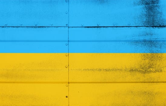 Grunge weathered national flag of Ukraine over studded steel armor metal surface background, symbol of Ukrainian patriotism