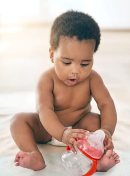 Did I just drink all of the milk. an adorable baby girl playing with an empty bottle at home