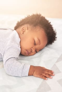 Its tiring work being this adorable. a little baby boy sleeping on a bed