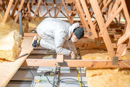 a worker in protective overalls works with glass wool. High quality photo