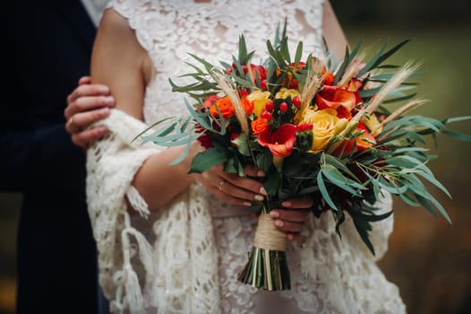 autumn wedding bouquet in the hands of the bride .Walk in nature.