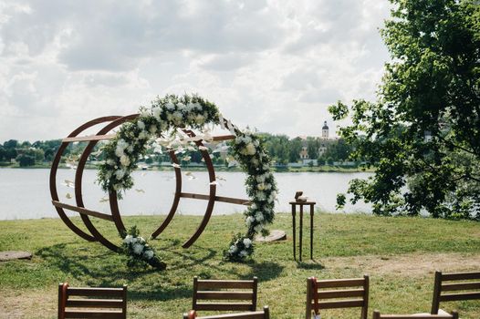 Wedding ceremony on the street on the green lawn.Decor with fresh flowers arches for the ceremony.