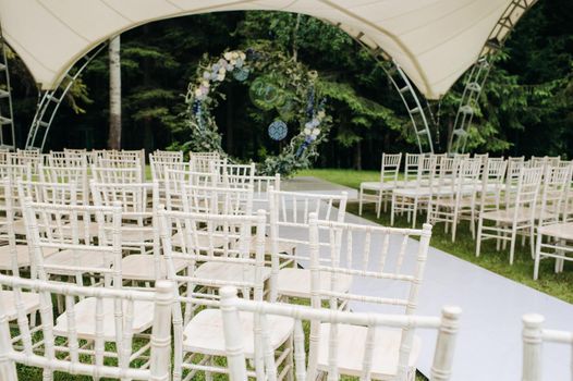 Wedding ceremony on the street on the green lawn.Decor with fresh flowers arches for the ceremony.