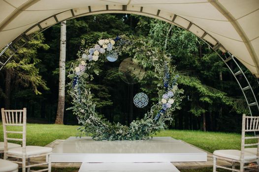 Wedding ceremony on the street on the green lawn.Decor with fresh flowers arches for the ceremony.