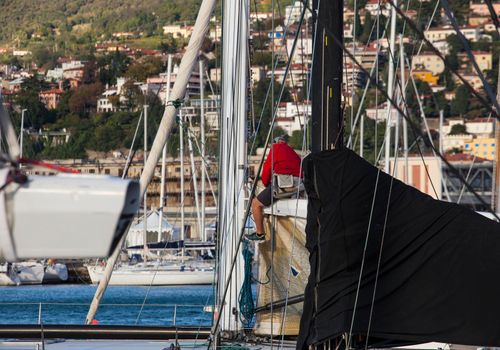 TRIESTE, ITALY - 06 OCTOBER 2017: Italian sailor working on tree of sailboat before the Barcolana race on 06 October, 2017