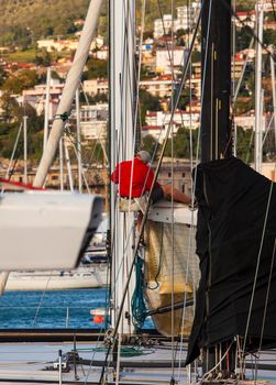 TRIESTE, ITALY - 06 OCTOBER 2017: Italian sailor working on tree of sailboat before the Barcolana race on 06 October, 2017