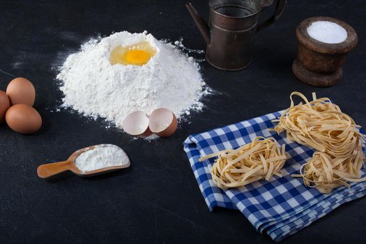 Italian homemade pasta called fettuccine on blue and white chequered dishcloth