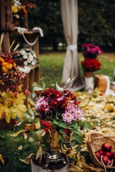 Autumn wedding ceremony on the street on the green lawn.Decor with arches of fresh flowers for the ceremony.