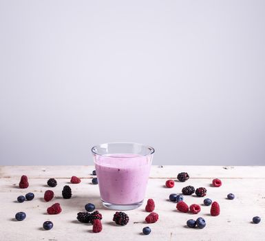 Yogurth with fresh berries on white table