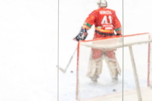 blurred view through protective safety glass. hockey goalie on the ice of the winter stadium. High quality photo
