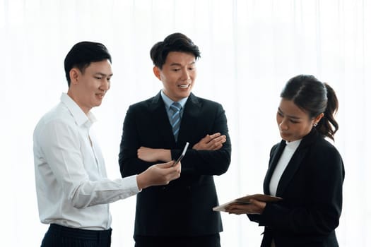 Mentor, manager advice younger colleagues in workplace. Businesspeople discussing or planning financial project strategy, talking together for harmony and strong teamwork in office concept.