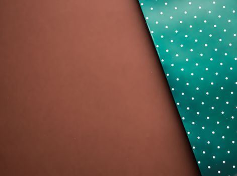 Abstract green polka dot background on brown backdrop.