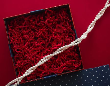Holiday gift, pearl jewellery necklace and beauty box subscription package mockup for luxury present, empty open gift box flat lay on red background as online shopping delivery, flatlay.
