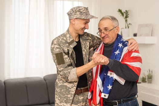 an elderly father and a military son saluting American flag.