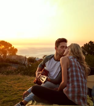 Out on a romantic roadtrip. a young man playing guitar for his girlfriend on a roadtrip