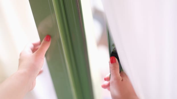 Woman tries to open door by holding window or door handle. Security and glass balcony doors