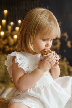 A little girl is sitting on the Easter table and playing with cute fluffy ducklings. The concept of celebrating happy Easter