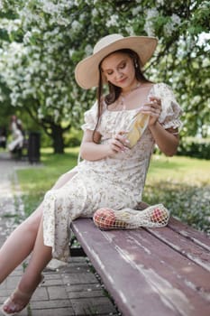 An attractive long-haired woman walks in the spring in the park of blooming apple trees. Spring portrait of a woman